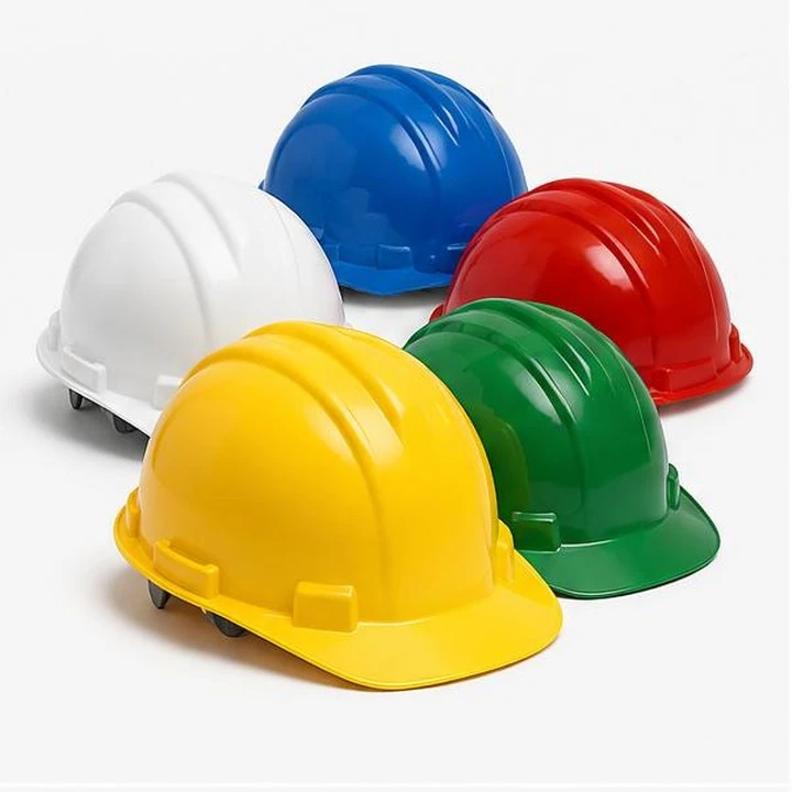Multiple colours of industrial safety helmets on a neutral product background